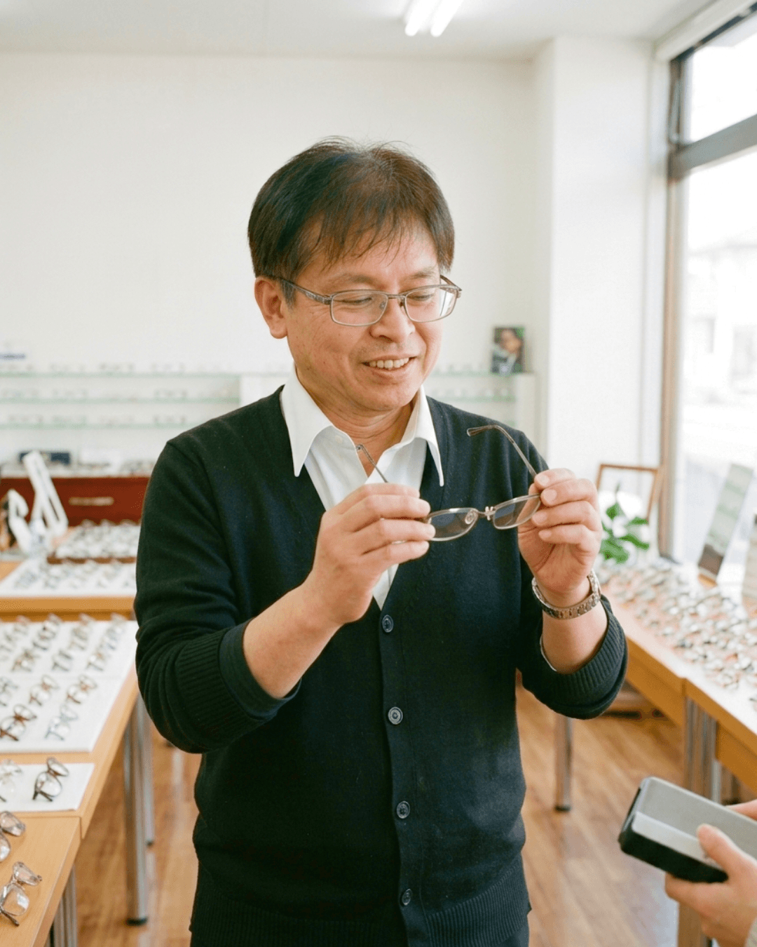 レンズや掛け心地を丁寧に確認するメガネショップまつうらの店主